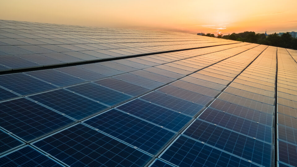Blue photovoltaic solar panels mounted on warehouse roof