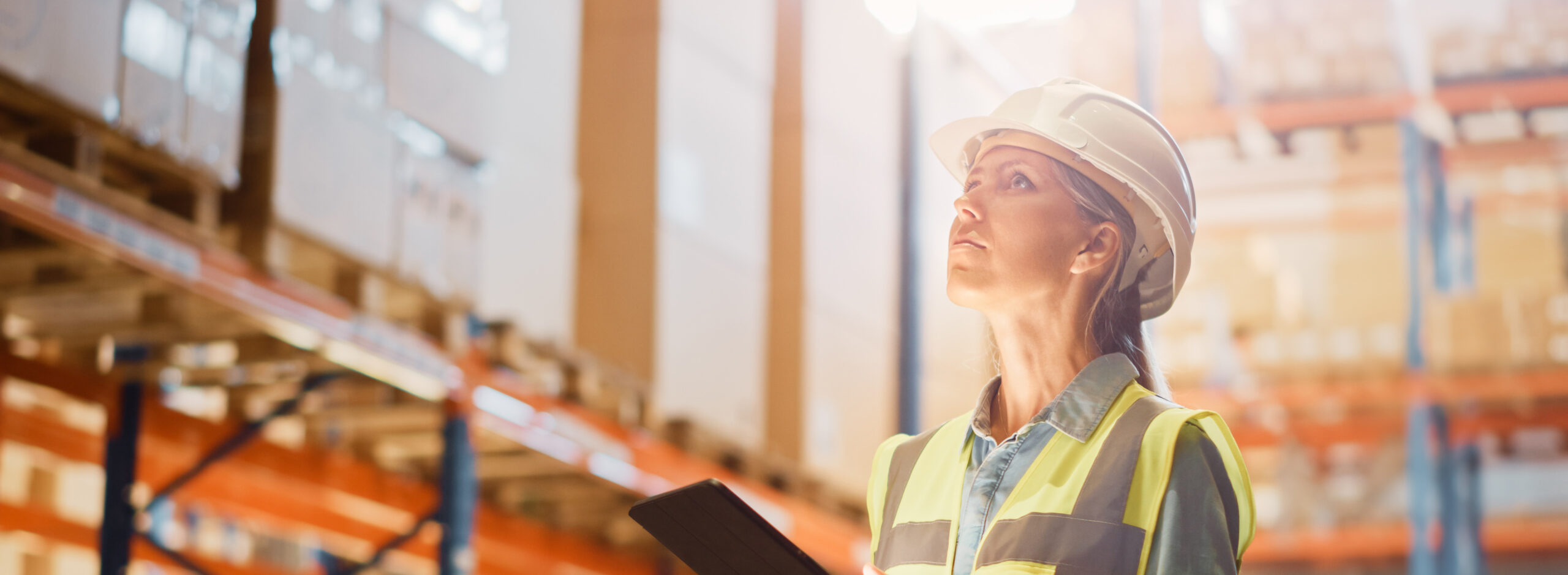 Health and safety racking inspection by a women in a hard hat and high visibility jacket