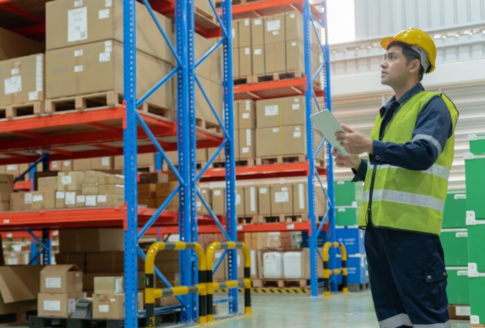 Man on a tablet in a warehouse performing a racking inspection